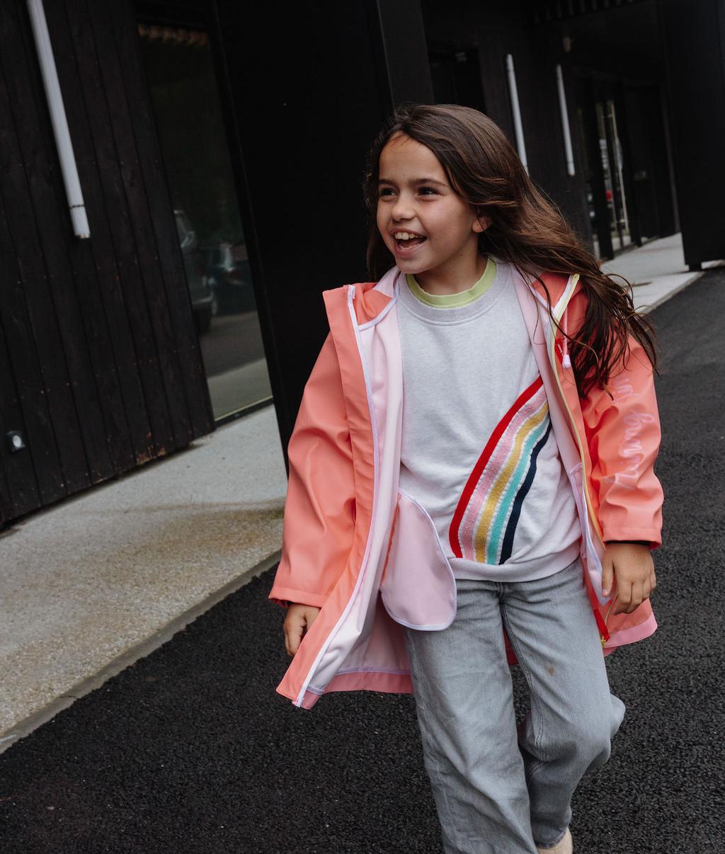 Fille portant le ciré de pluie imperméable avec capuche Pink, non zippé – photo lifestyle – Hello Hossy