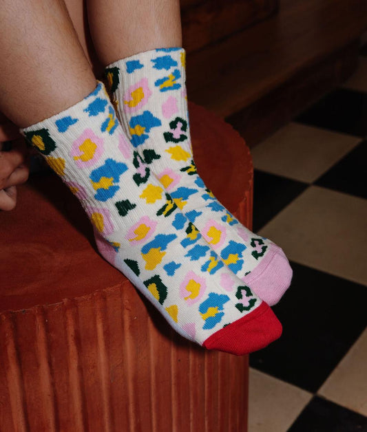 Enfant portant une paire de chaussettes motif léopard coloré – vue de 3/4 – Hello Hossy