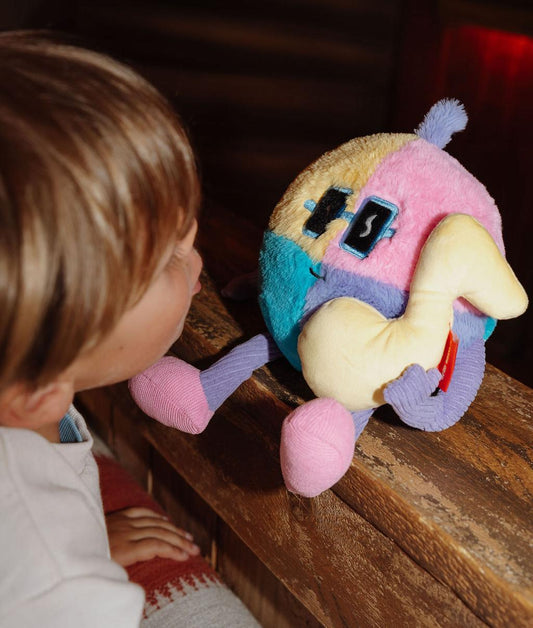 Peluche douce Disco Pop posée sur une rampe avec un enfant la regardant - jouet original - Hello Hossy