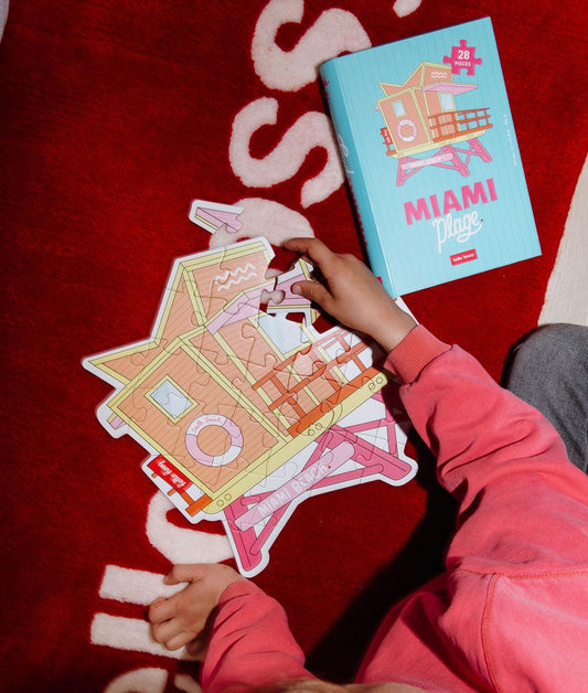 Puzzle coloré "Miami Plage" assemblé sur un tapis au sol avec la boîte à côté - vue du dessus - Hello Hossy