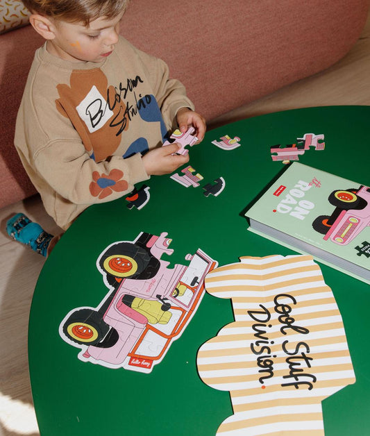 Enfant jouant avec le puzzle 24 pièces "On The Road" – vue du dessus – Hello Hossy