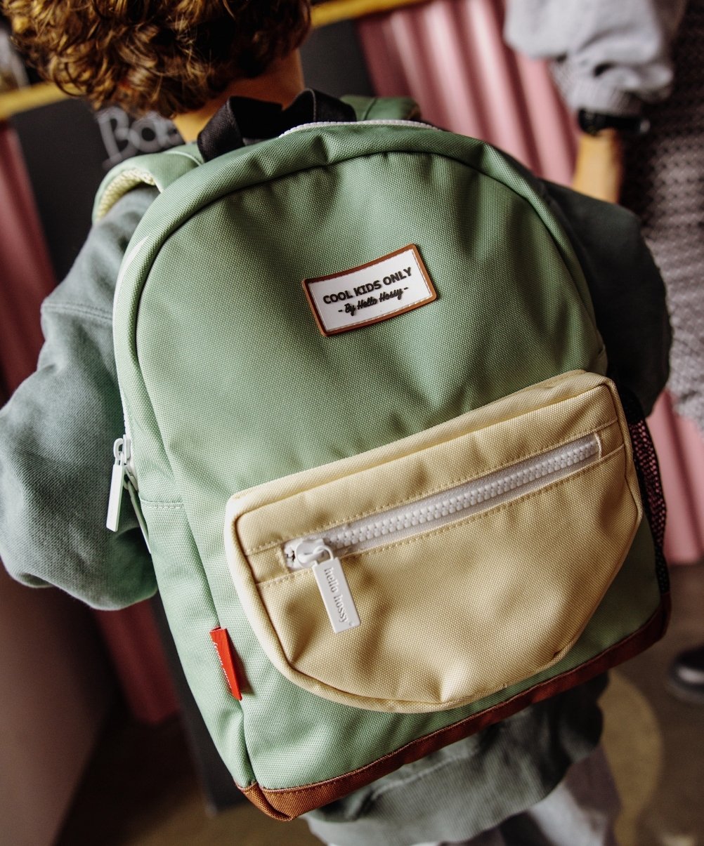 Sac à dos enfant vert poche beige fermeture blanche patch texte Hello Hossy